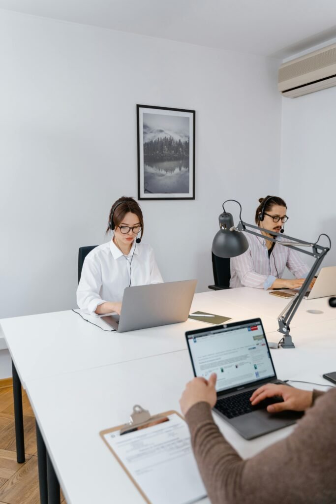 Diverse team working together on laptops in a modern office environment.